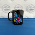 A striking black mug featuring a vibrant faux‑denim patchwork bee design. Bright, bold, and perfect for anyone who loves unique, colourful artwork on their everyday mug.